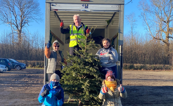 volunteers collecting old christmas trees for recycling